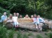 Children and adults pose with sculpted bench which includes inscription Welcome to Owley Wood